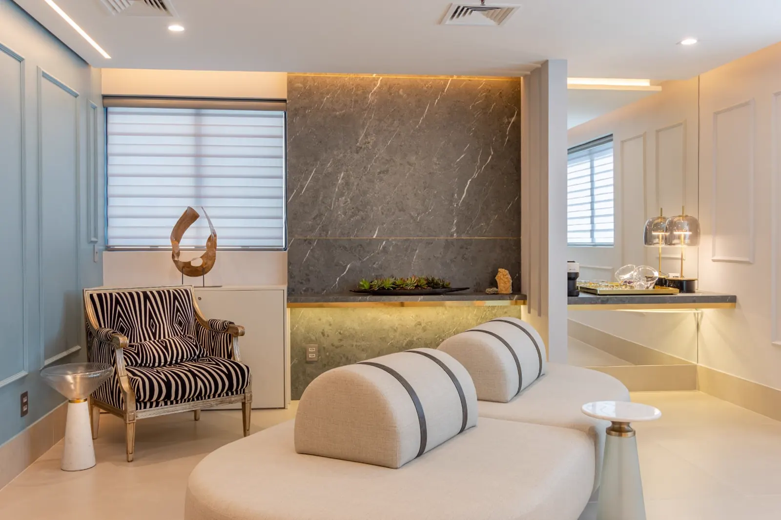 Lounge com painel de pedra iluminado e poltrona clássica